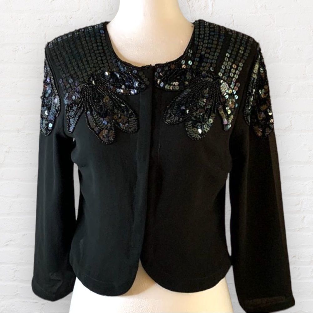H&M black cropped sequin embellished top. Fastens in the middle w/ 3/4 sleeves 6